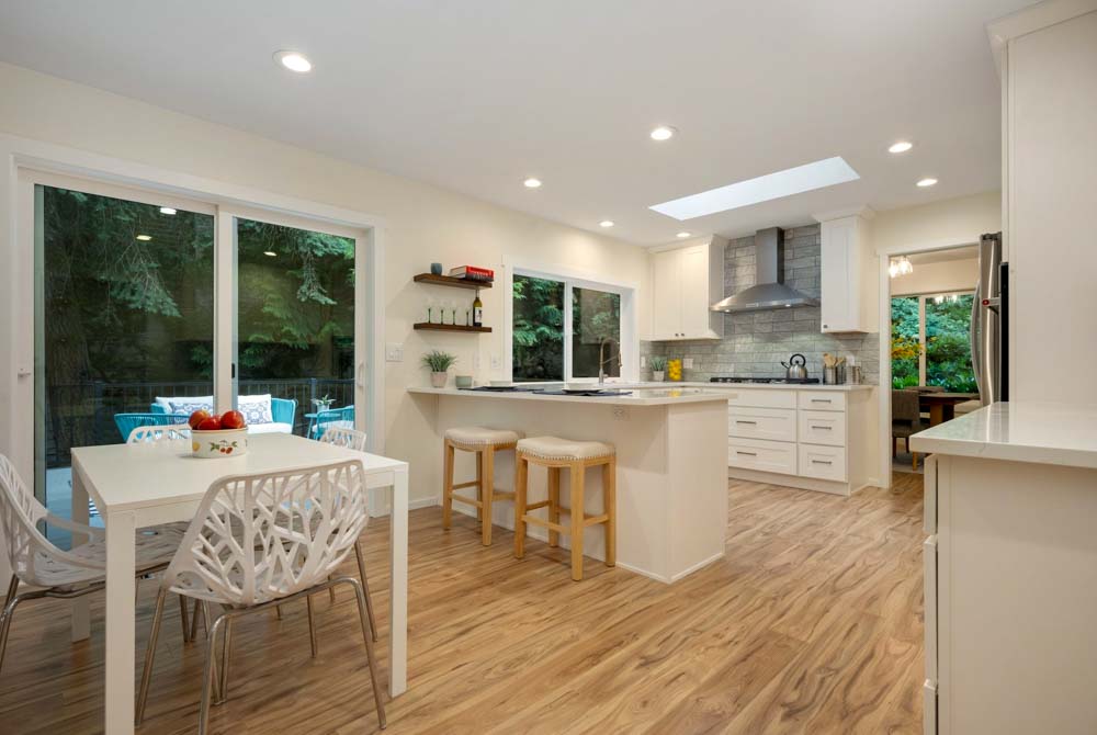 Raised kitchen interior: walls painted off-white and ceiling as white, matching the dining set, cabinets, and bar