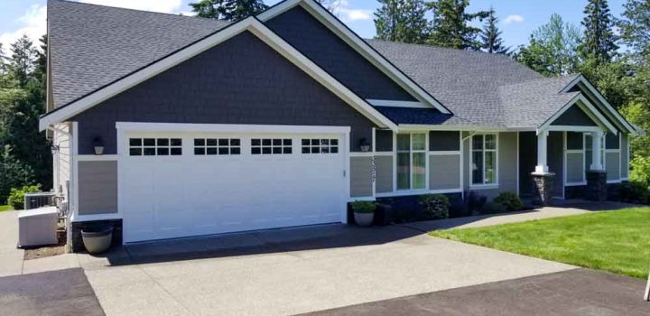 A Modern House Exterior view from the driveway. Exterior painted dark gray while white for the frames and edges